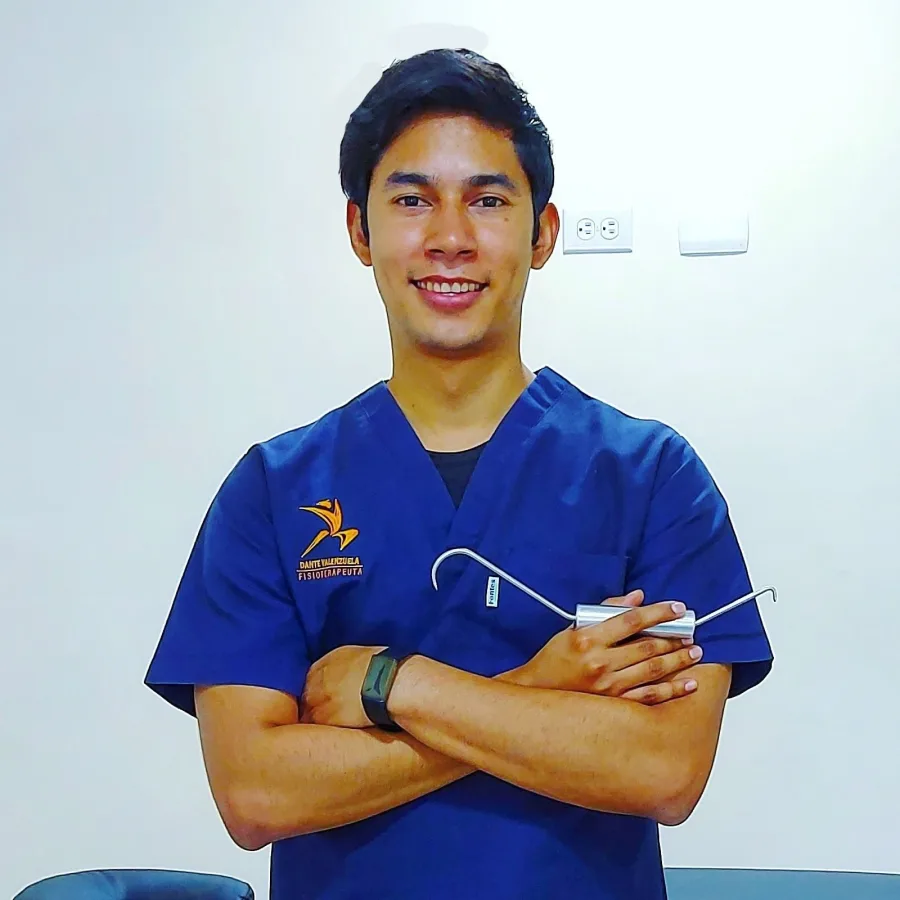 Retrato de Dante Valenzuela, fisioterapeuta, con bata azul de trabajo