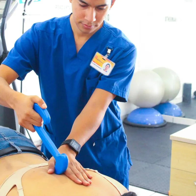 Dante aplicando terapia manual con instrumento (IASTM) en la espalda de un paciente